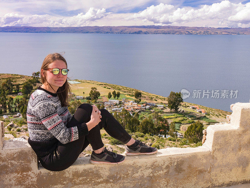 年轻女子的肖像坐在美丽的风景上的太阳岛，isla del sol，秘鲁